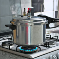 Pressure cooker under the stove fire
