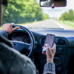 man using smartphone while driving